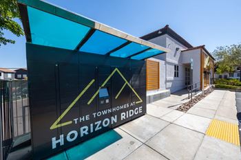 A sign for The Townhomes at Horizon Ridge is displayed in front of a building.