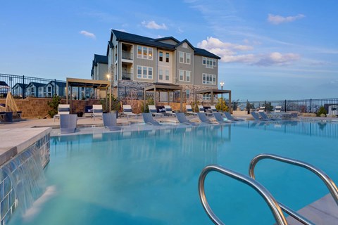 A large swimming pool in front of a multi-story building.