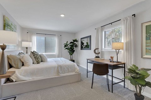 A bedroom with a bed, desk, and chair.