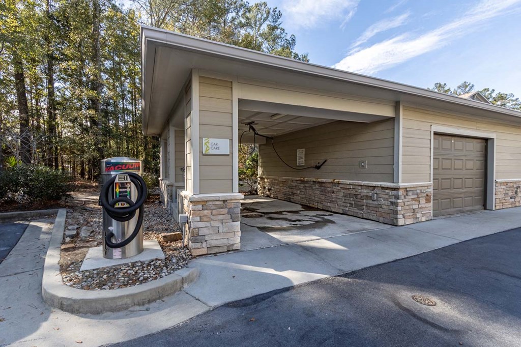 A carport with a garage door and a parking meter in front of it.