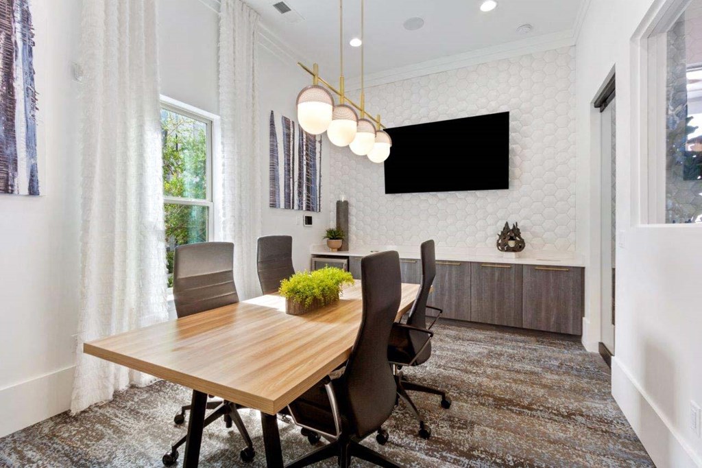 A conference room with a long table and chairs.