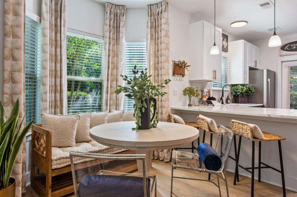 A dining area with a round table and chairs.