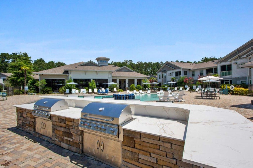 2-Bedroom Apartments in Downtown Savannah, GA - Adara at Godley Station - Grilling Station with a Brick Kitchen, Countertop, Two Built-In Stainless Steel Grills, Overlooking the Pool Area.