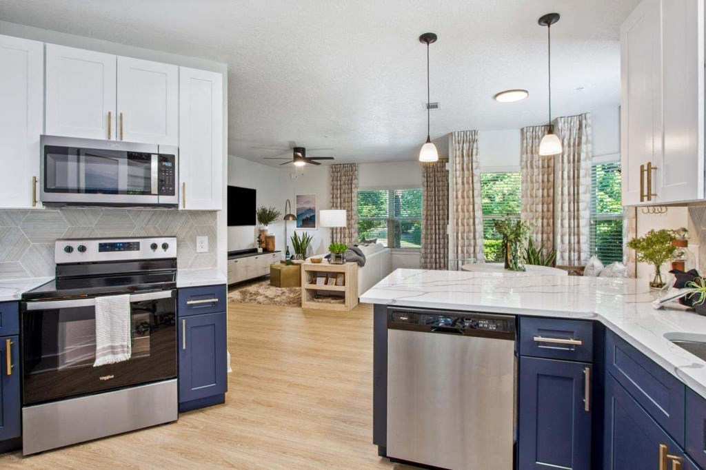 A modern kitchen with a stainless steel oven and blue cabinets.