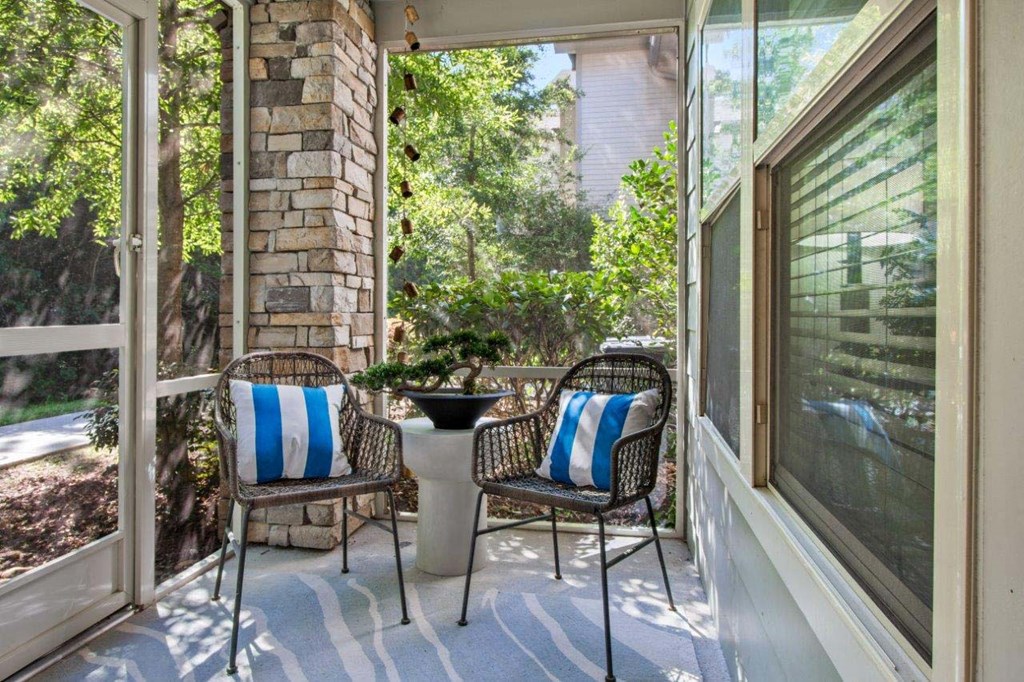 Two chairs with blue and white stripes sit on a porch.