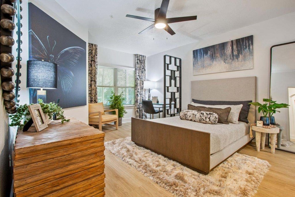 A bedroom with a large bed and a wooden dresser.