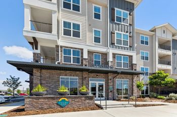 A multi-story apartment building with a sign that reads "FALLS".