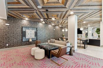 A modern living room with a patterned carpet and a wooden coffee table.