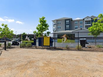 A large grey building with a yellow dumpster in front of it.