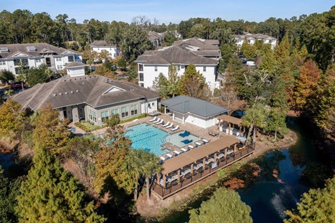 A large white building with a pool in front of it.