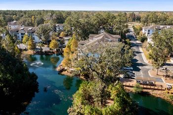 A serene lake surrounded by houses and trees.