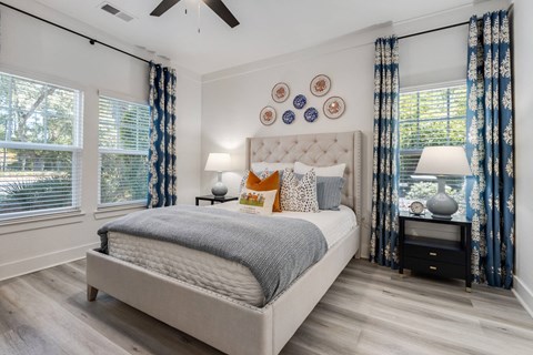A bedroom with a large bed and a ceiling fan.
