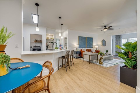 A modern living room with a blue table and wooden chairs.