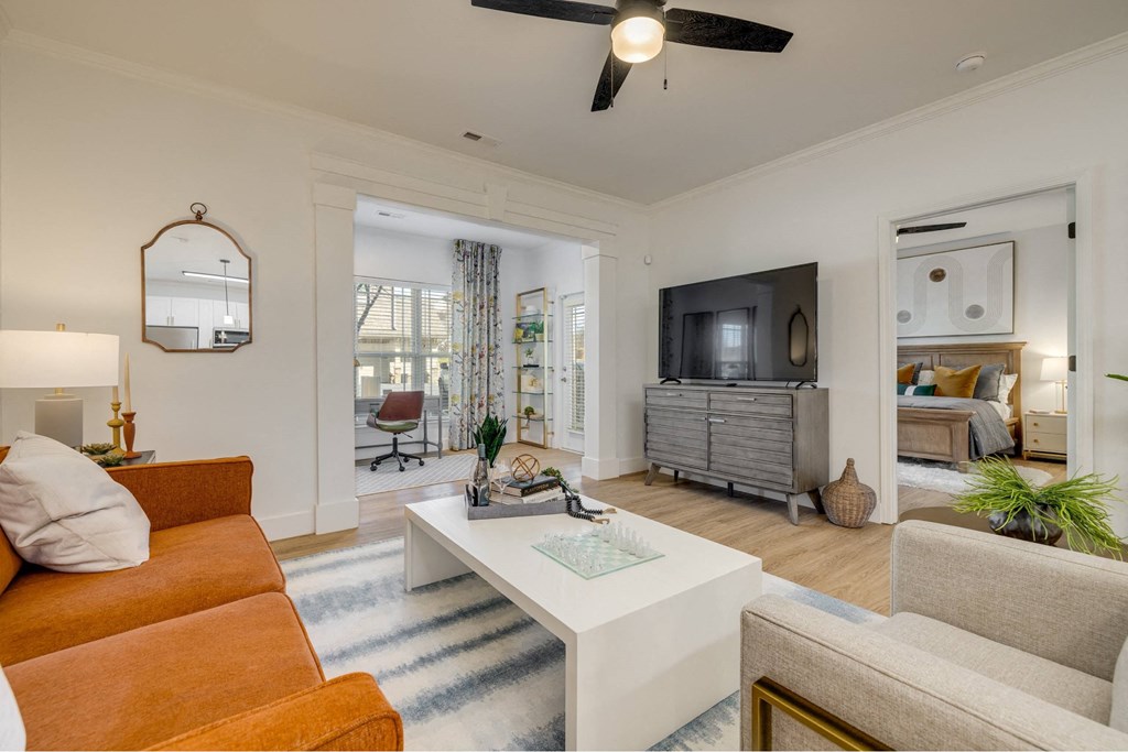 A living room with a white sofa and a white coffee table.