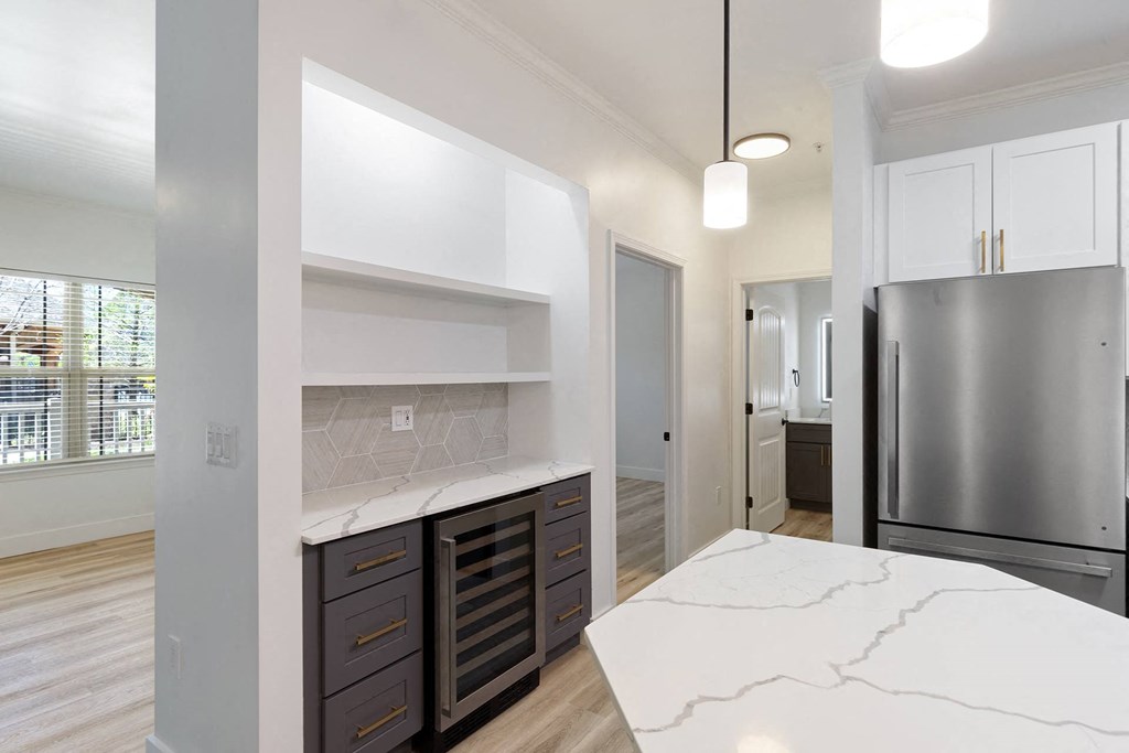 A kitchen with a marble counter top and stainless steel appliances.