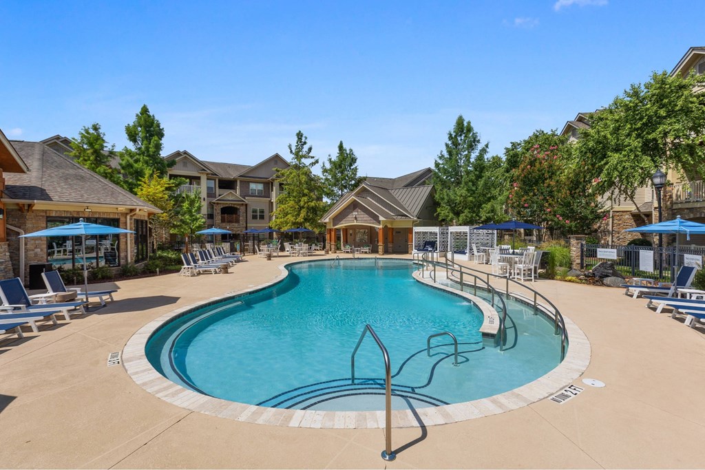luxury apartments in Charlotte NC with In-Unit Washer and Dryer - The Banks at Rivergate - A large outdoor swimming pool surrounded by lounge chairs and umbrellas.