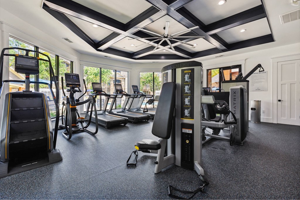 A gym with a variety of equipment including treadmills, stationary bikes, and weight machines.