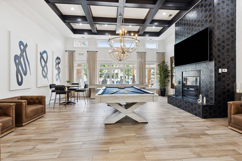A living room with a pool table and a fireplace.