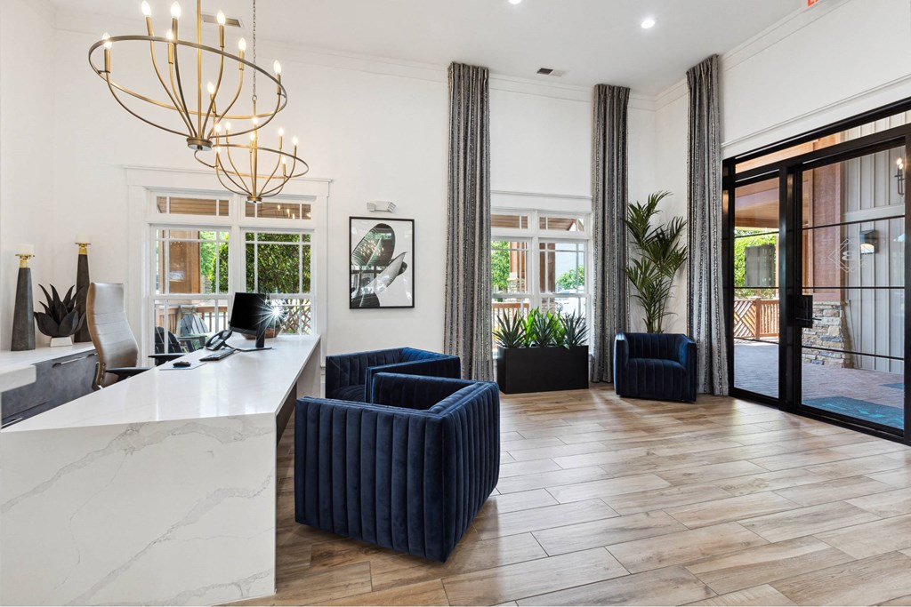 A white reception desk with a white marble top and a white counter.