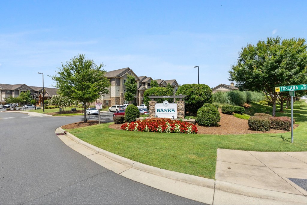 A street view of a residential area with a sign that reads