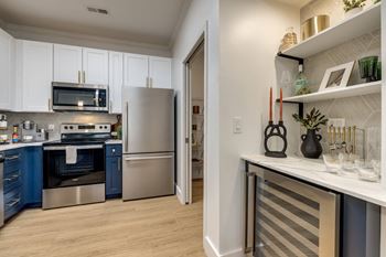 A kitchen with a refrigerator, oven, and microwave.