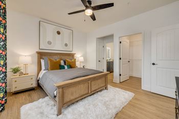 A bedroom with a bed, nightstand, and a ceiling fan.