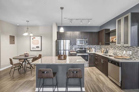 A modern kitchen with a dining table and chairs.