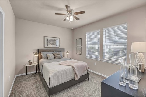 A bedroom with a large bed and a ceiling fan.