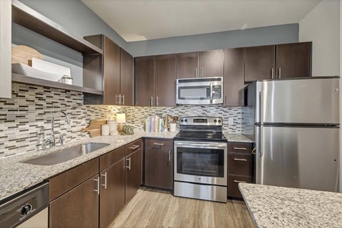A modern kitchen with stainless steel appliances and wooden cabinets.