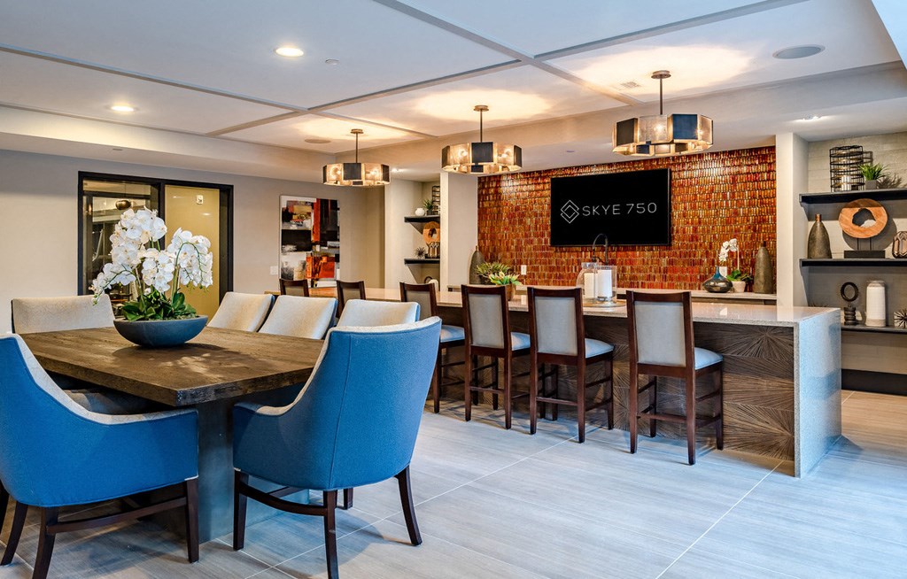 A modern dining room with a wooden table and blue chairs.