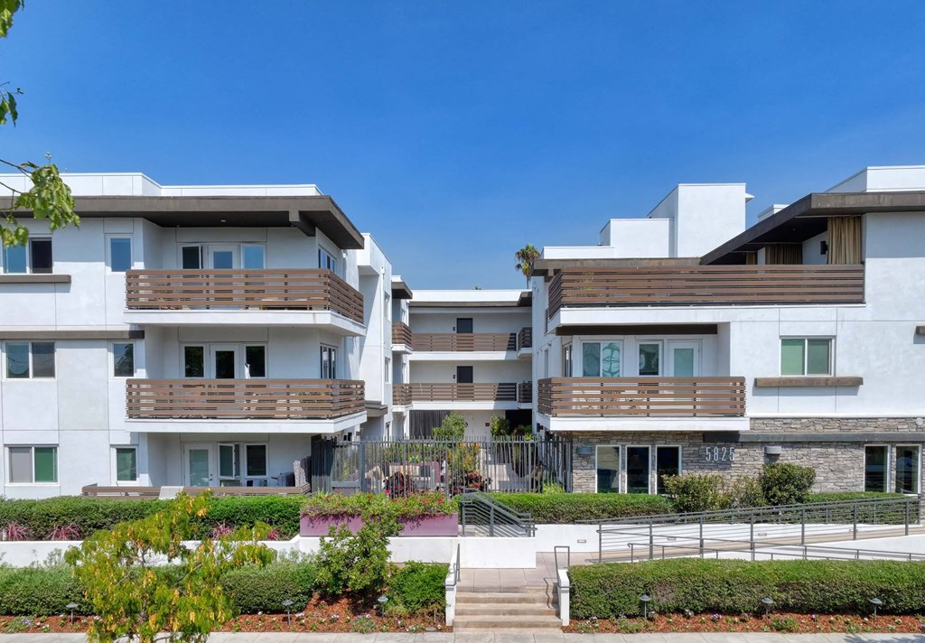 A modern apartment complex with white buildings and balconies.