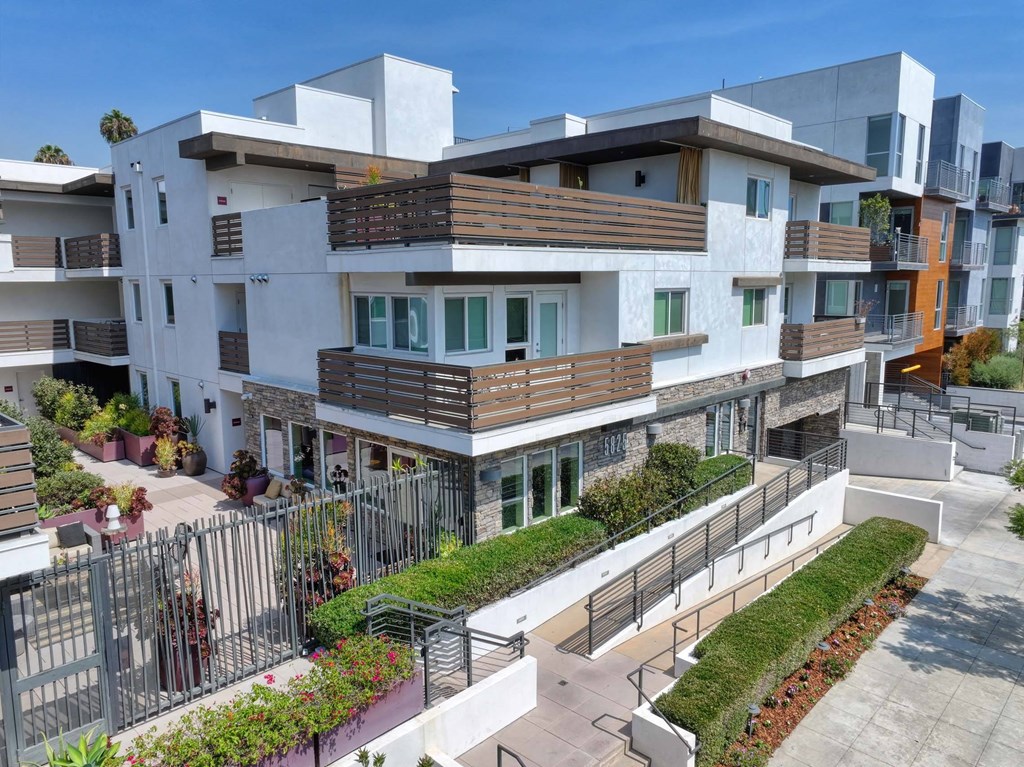 A modern apartment complex with a mix of white and brown balconies.