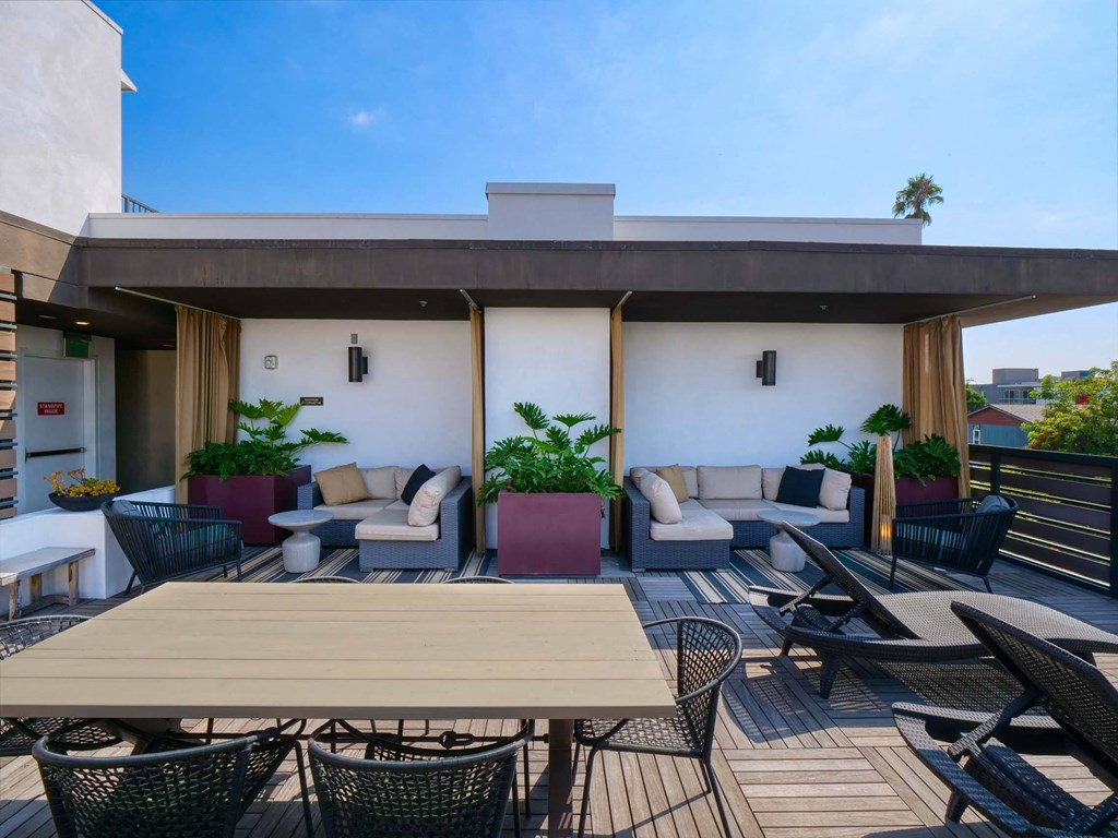 A patio with a table and chairs is set up on a balcony.