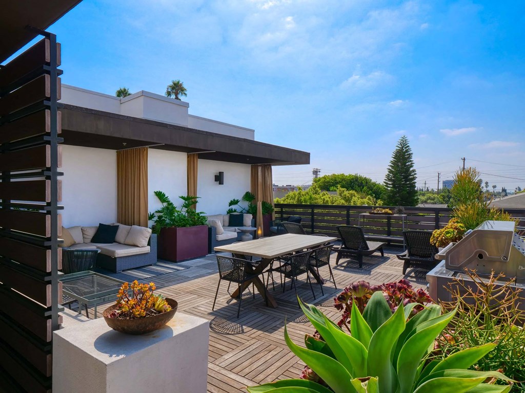 A modern house with a wooden deck and patio furniture.