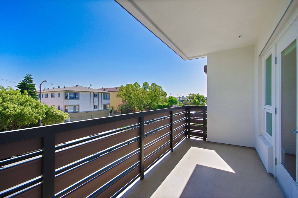 A balcony with a railing overlooks a residential area.