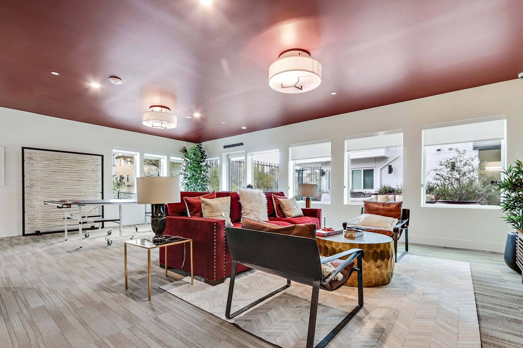 A modern living room with a red sofa and a glass coffee table.
