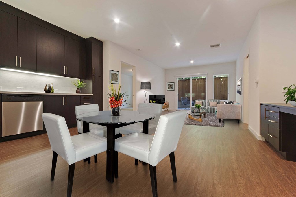 A modern dining room with a black table and white chairs.