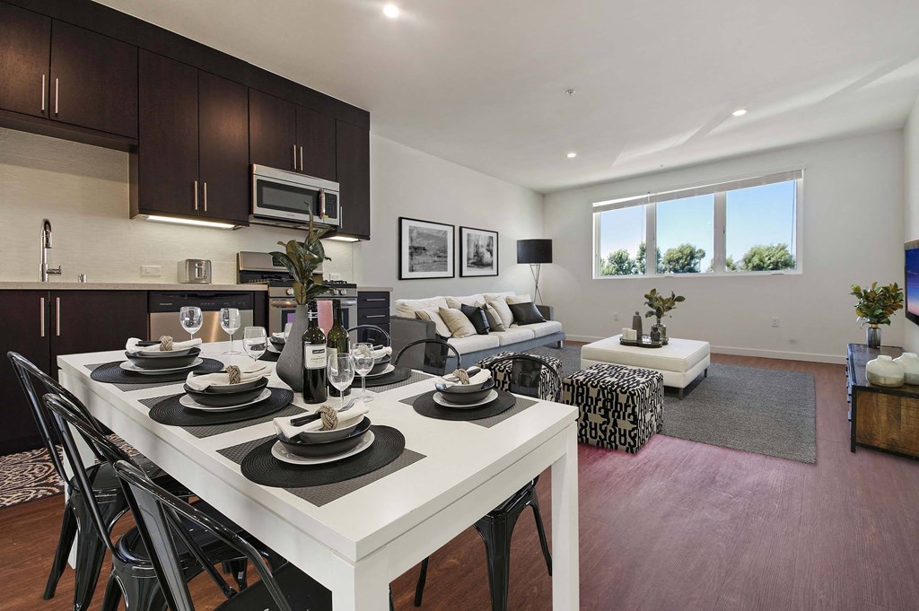A modern dining room with a white table set for six.