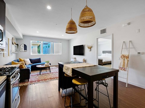 A modern kitchen with a black stove top oven and a black bar stool.