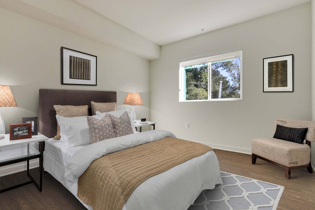 A bedroom with a large bed and a chair.