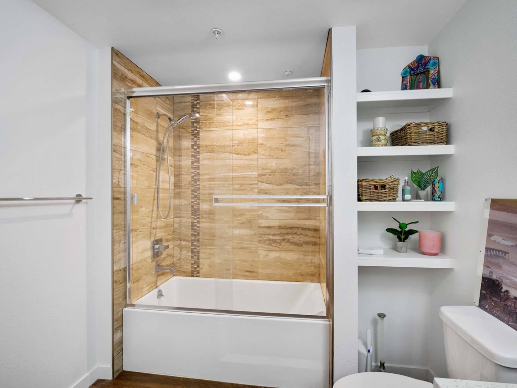 A white bathroom with a walk-in shower and a toilet.