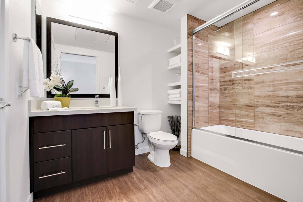 A bathroom with a toilet, sink, and a mirror.