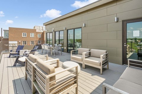 A patio with wooden furniture and a building in the background.