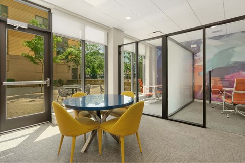 A conference room with a glass wall and yellow chairs.