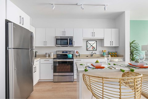 A modern kitchen with a dining table set for two.