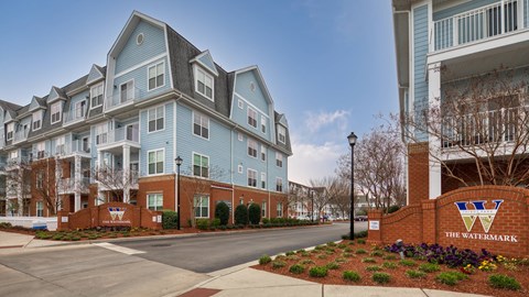 A large blue and white apartment building with a sign that says "The Watermark".