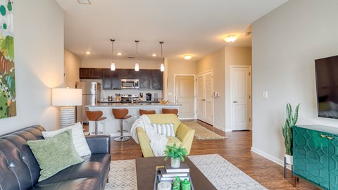 A modern living room with a bar area and a kitchen in the background.
