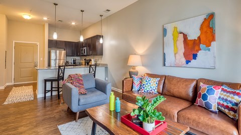 A living room with a brown couch and a grey armchair.