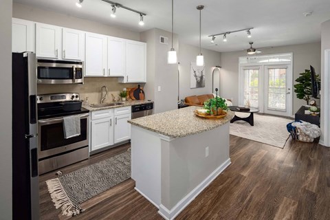 A kitchen with white cabinets and a wooden island.