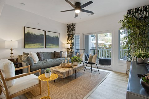 A living room with a grey couch, a yellow side table, and a painting on the wall.